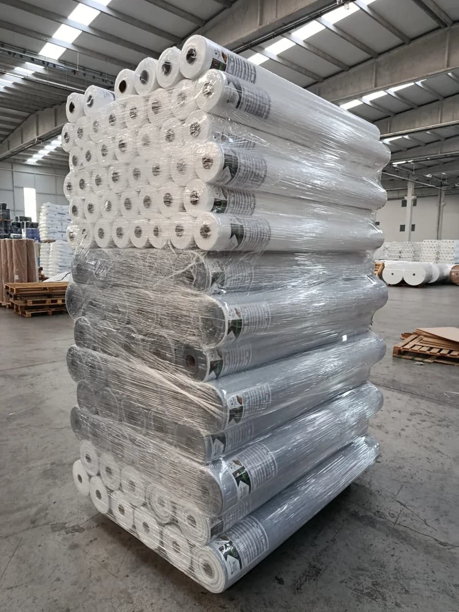 Stretch-wrapped pallet of white vapour barrier rolls in a warehouse